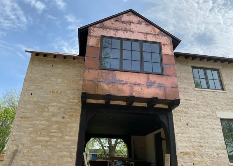 Copper metal panel facade on a stone building for Roof Repair in Chaska